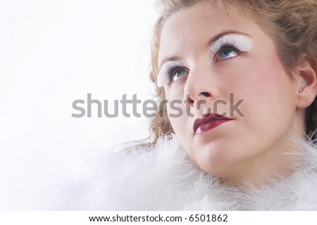 woman in white angel costume with big wings looks to heaven