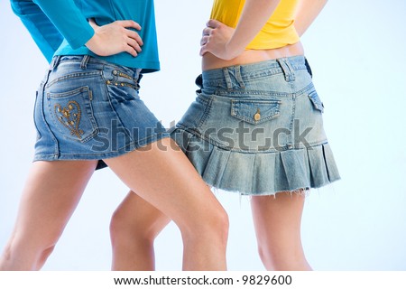 legs of two women wearing denim mini-skirts