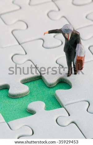 A man is standing in front of a missing jigsaw puzzle piece