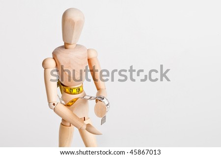 Wooden figure is doing body measurements with a tape