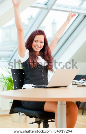 jubilating female clerk with laptop sitting in office