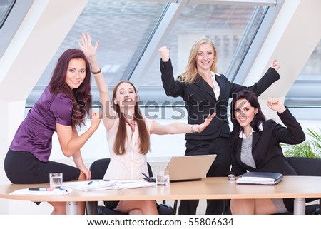 smart women in business outfit cheering in front of the window