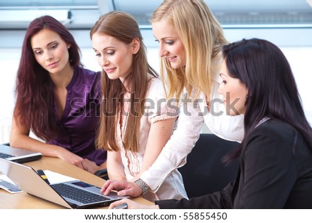 four young women working on the same document
