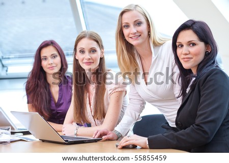 four young women in business look helping each other