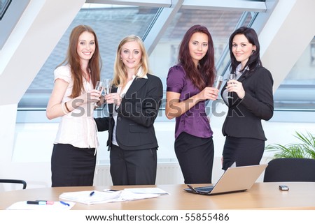 young ladies in business outfit clinking glasses