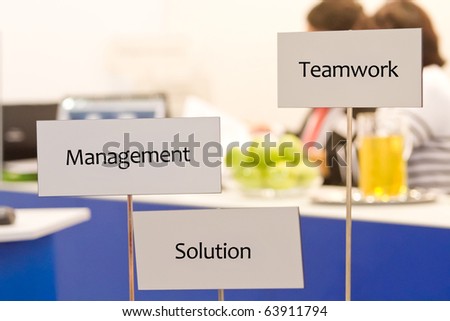 teamwork, solution and management is written on the  signpost at the welcome desk