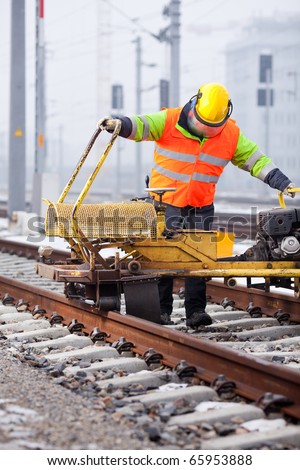 a railroad worker grinds the rails with his machine