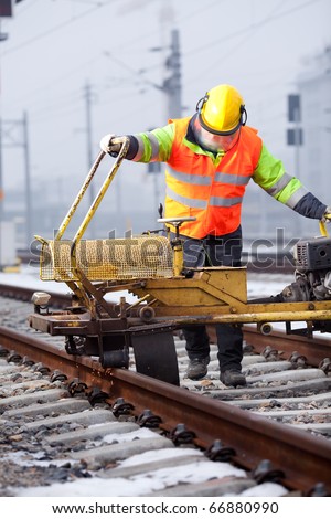 a railroad worker repairs rails with his machine
