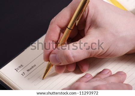 Hand of businessman taking notes at board meeting