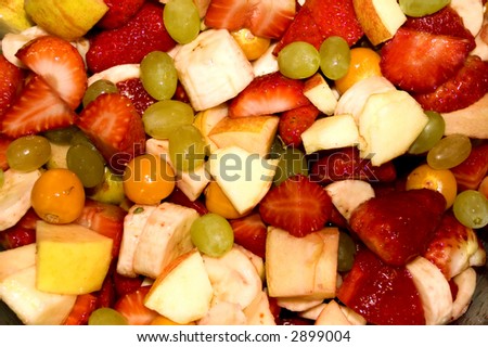 Closeup of fruit salad with strawberries, apples, graped and physialis