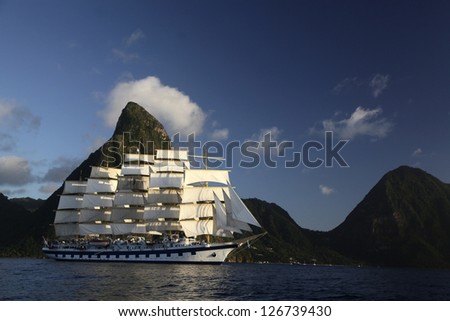 A Modern Clipper ship under full sail passing under the peaks of St. Lucia\'s Grand Tetons