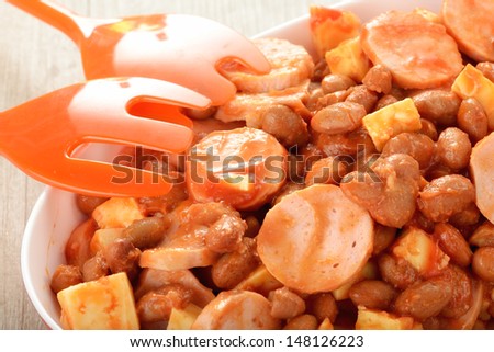 Salad with German sausage, beans and cheese topped with ketchup