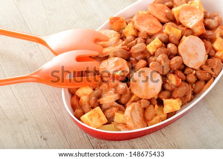 Salad with German sausage, beans and cheese topped with ketchup