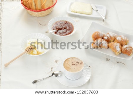 Breakfast with cappuccino and croissant