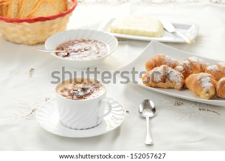 Breakfast with cappuccino and croissant