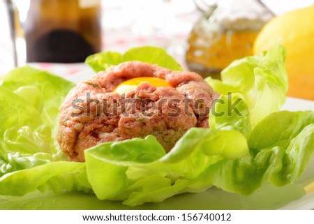 ground beef tartare with raw egg on a bed of salad