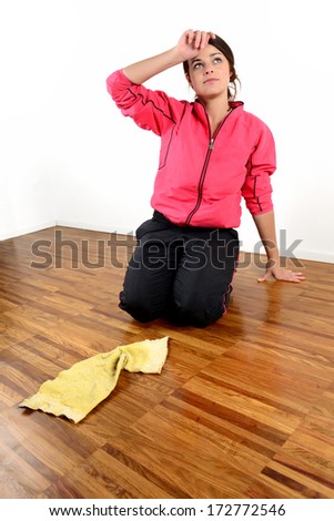 Tired girl mopping the floor