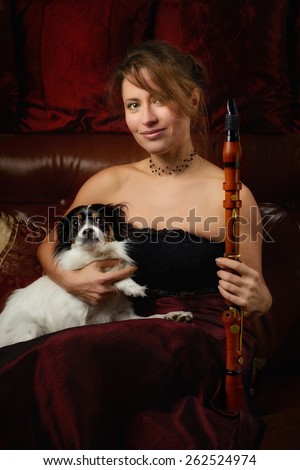 Blonde girl with vintage clothing and antique clarinet pet dog