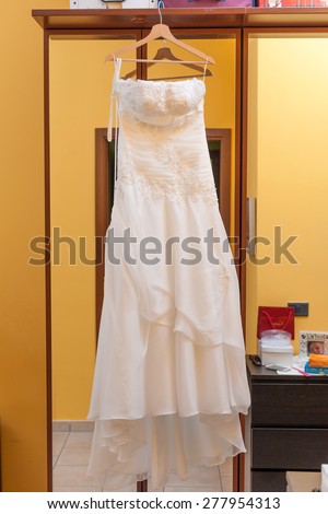 wedding dress hanging from a mirrored wardrobe