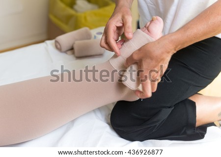 bandages legs and manual lymphatic drainage massage for a patient with swelling effect