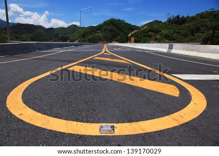 Yellow line on highway with mountain view and blue sky