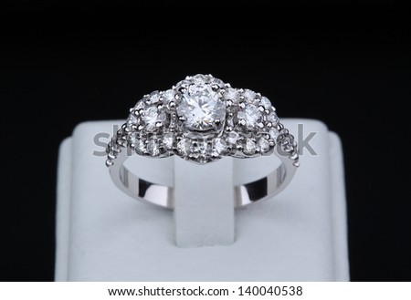 White gold diamond ring with stand on black background
