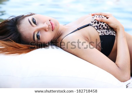 Sexy bikini young woman on deck chair