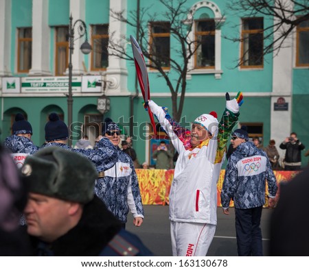 VLADIVOSTOK, RUSSIA - NOVEMBER 16: torchbearer carries the Olympic flame in relay of Olympic Flame on November, 2013 in Vladivostok, Russia.