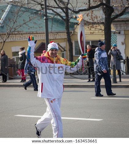 Vladivostok, Russia - November 16: Torchbearer Carries The Olympic Flame In Relay Of Olympic Flame On November 16, 2013 In Vladivostok, Russia.