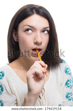 Pretty girl thinking with a pen in mouth, isolated on white.