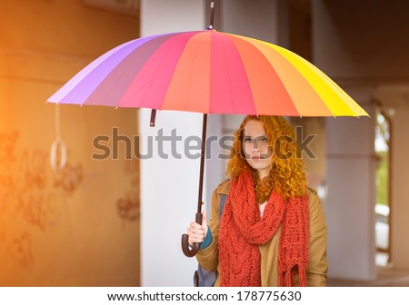 Beautiful redhead girl with umbrella in the sunshine.