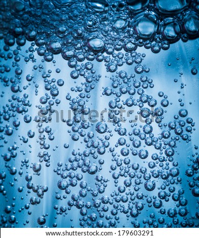 Oxygen bubbles in the bottle with water or drink. Selective focus on center with shallow depth of field.