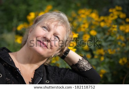 Portrait of beautiful aged woman in the park. Selective soft focus on eyes.