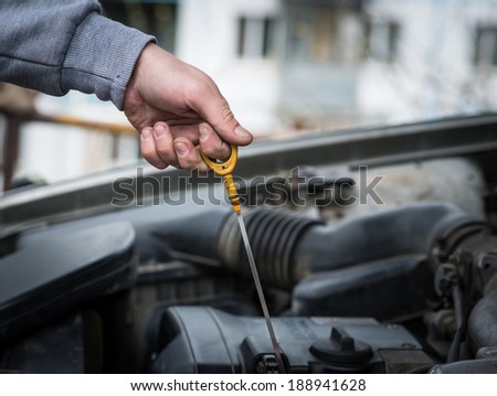 Auto Mechanic checking oil. Selective focus with shallow depth of field.