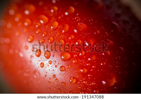 Super macro shot of tomatoes surface with water drops. Selective focus with very shallow depth of field.