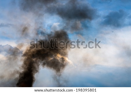 Black smoke over cloudy sky.
