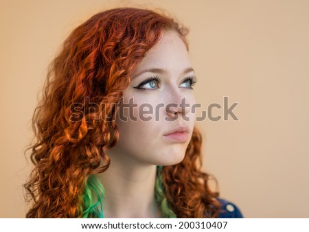 Close-up natural portrait of young redhead woman. Selective focus with shallow depth of field.