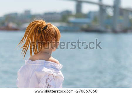Young asian woman looking on sea. Photo from behind.
