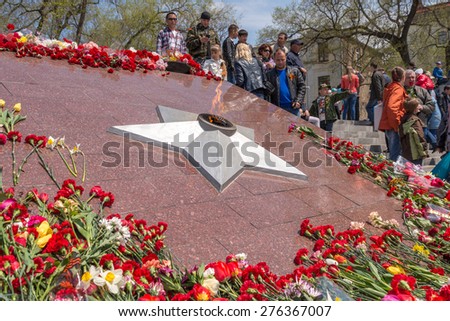 VLADIVOSTOK, RUSSIA - MAY 9, 2015: Eternal fire surrounded by flowers on May 9th in day of Victory.