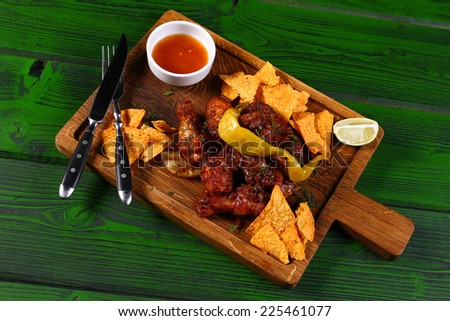 Grilled chicken with chips and jalapeno pepper on wood board