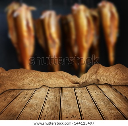 Empty wooden table and smoked fishes in background. great for food product display montages.