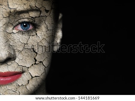 Woman face covered with cracked earth texture - symbol of nature disaster or skin care