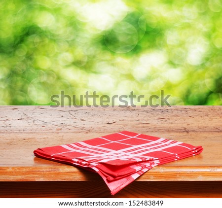 Empty wooden table and fresh green bokeh bubbles in background