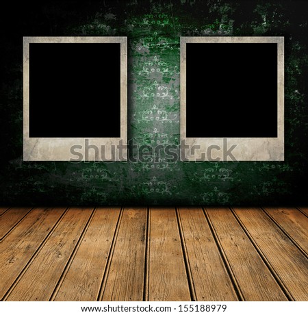Dark room with old wallpaper, wooden floor and retro photo frames