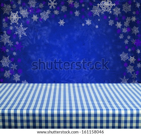 Empty gingham table with blue christmas background