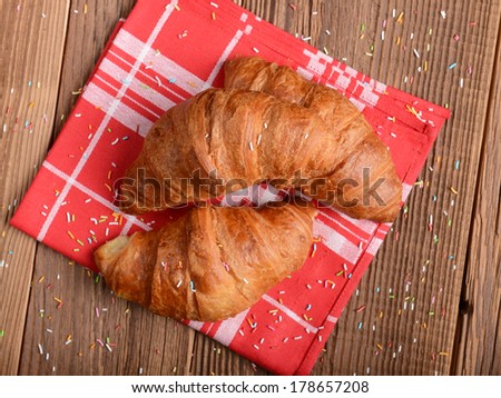 Fresh baked croissants on wooden background