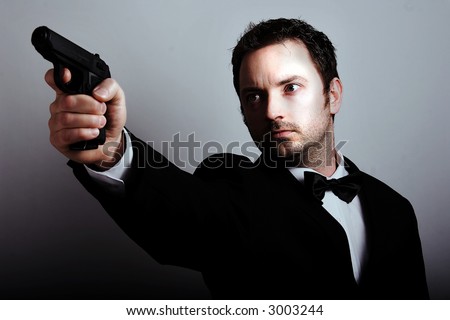 A man in a suit pointing a gun