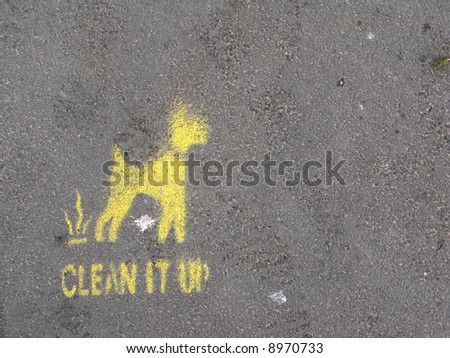 A sprayed on sign asking dog walkers to clean up their mess
