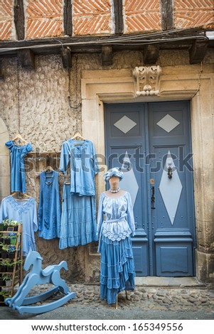 LAUTREC, FRANCE - JULY 8, 2013: Exterior of a typical shop in Lautrec (Tarn) on July 8, 2013. Selling traditional clothes and potted plants.