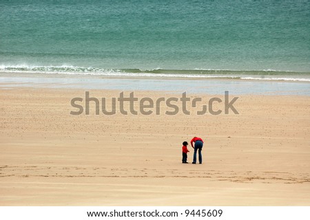 The beach of Sables d\'Or-les Pins, in Brittany, France: mother and son